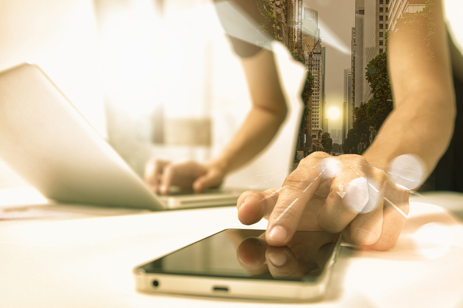 hands interacting with devices in a bustling urban setting