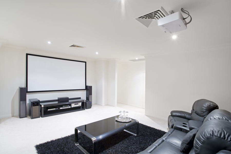 projector displaying on screen in modern home theater room