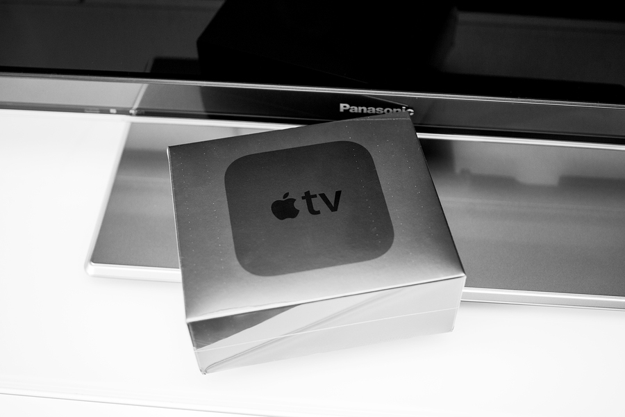 apple tv box resting on a panasonic television stand.