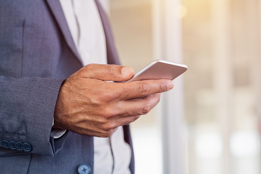 businessman holding a smartphone in an office setting.
