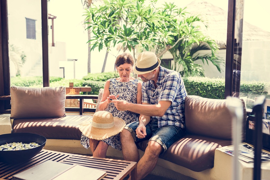 elderly couple relaxing on patio wearing summer hats