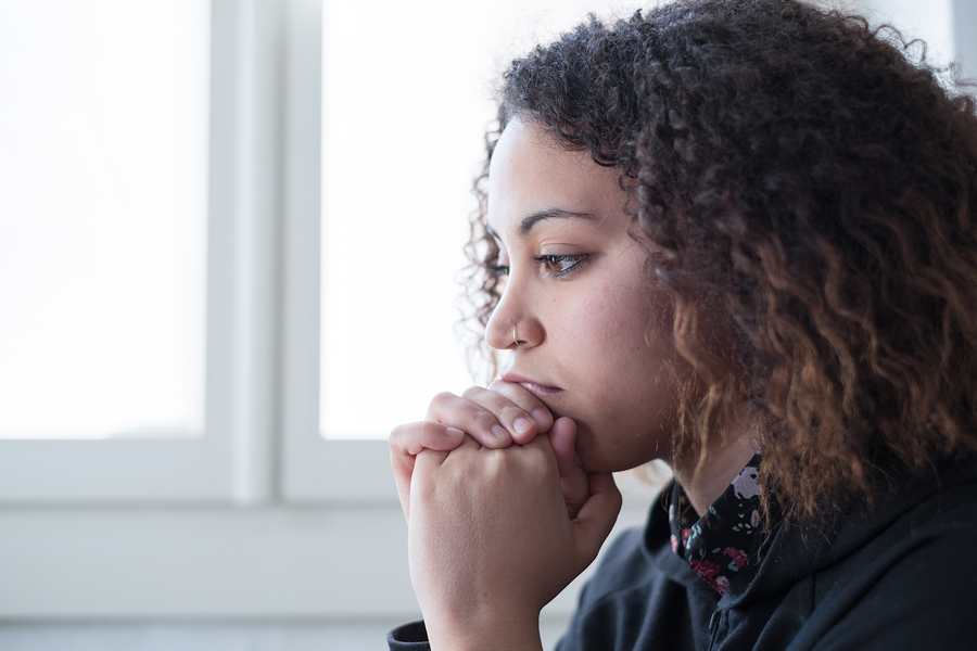 woman contemplating deeply by window in bright room