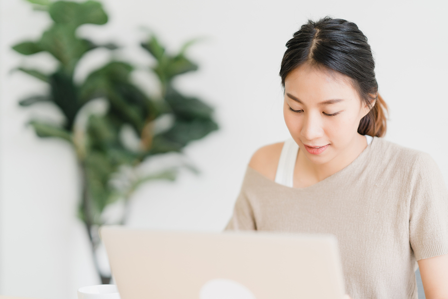 person reading something on laptop in a bright office