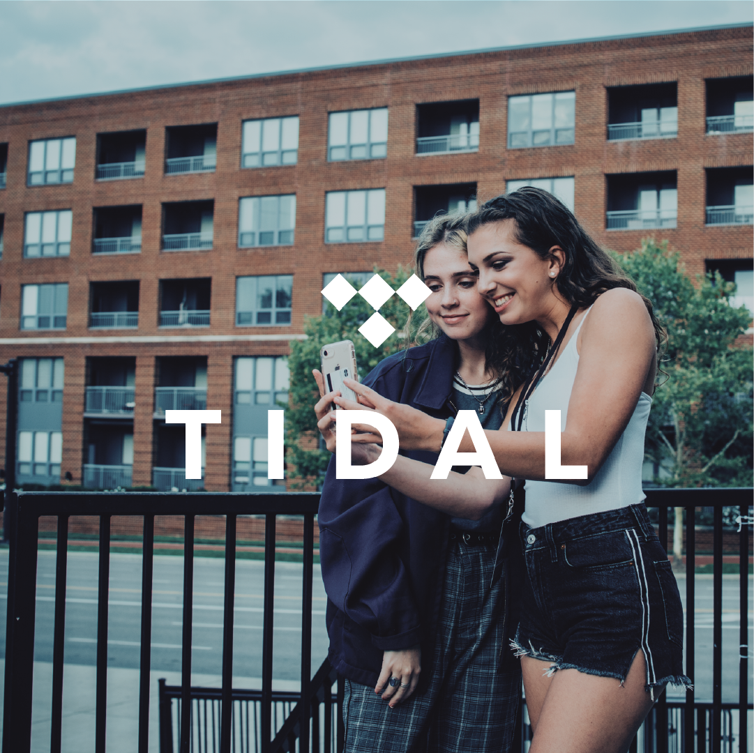 two friends sharing a phone moment by the tidal brand.