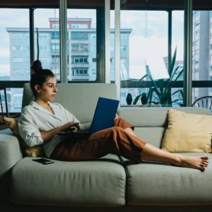 Woman on lounge working on laptop
