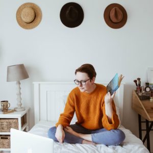 Woman on bed watching laptop