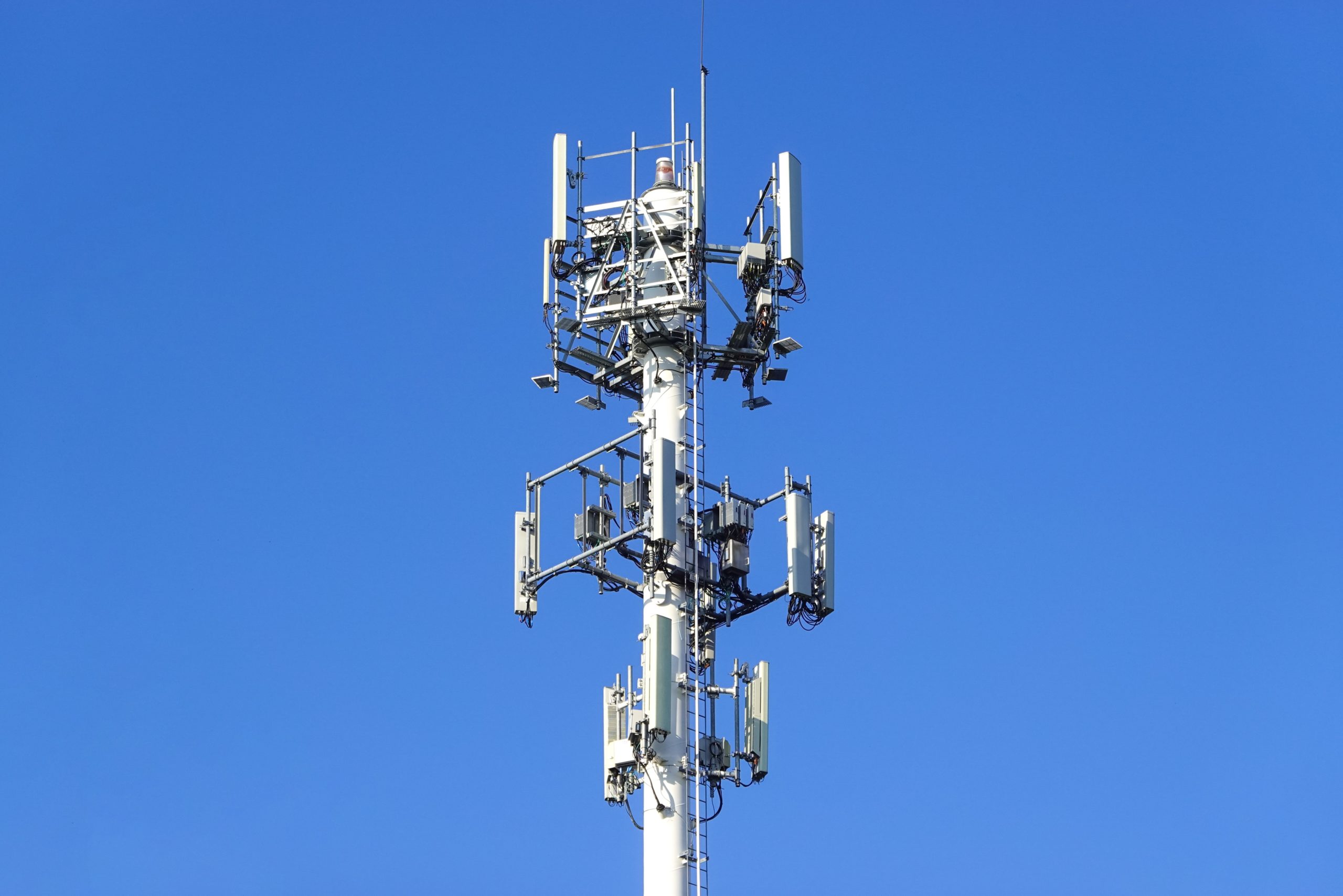 cell tower standing against clear blue sky