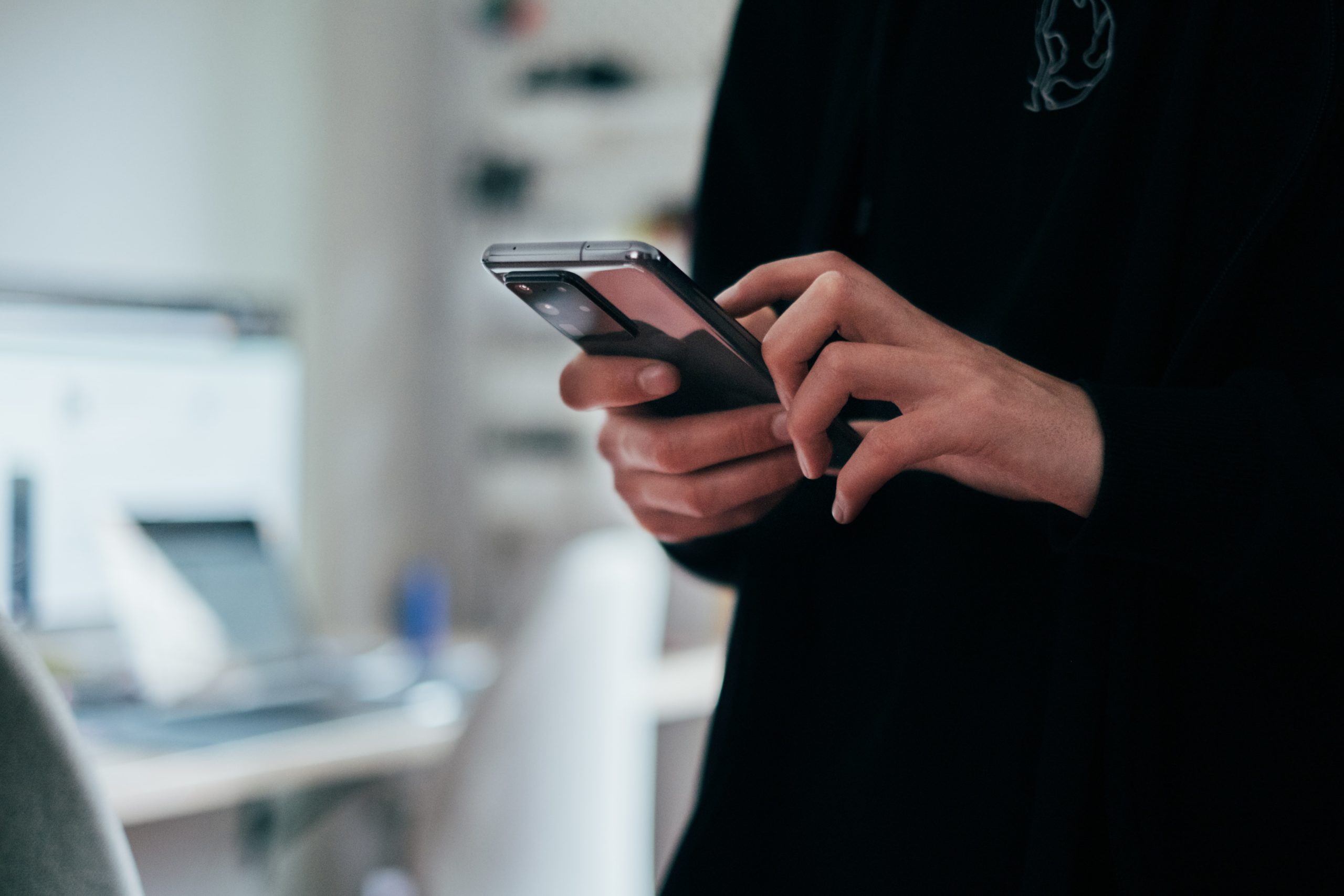 hands texting on smartphone in a dimly lit room