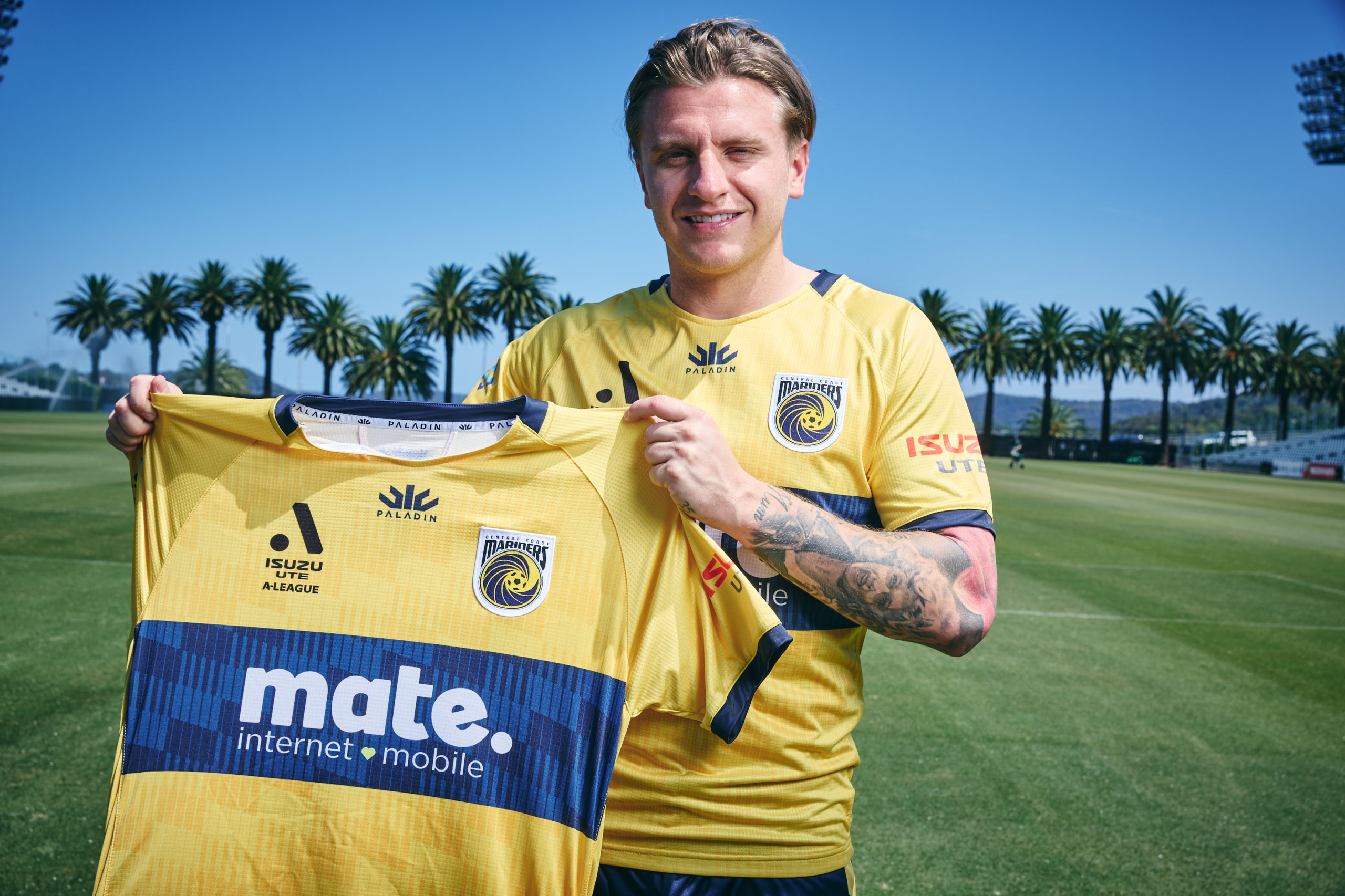soccer player holding jersey on sunny field by the mariners.