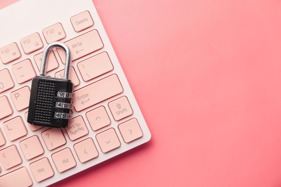 lock resting on pink computer keyboard against matching background