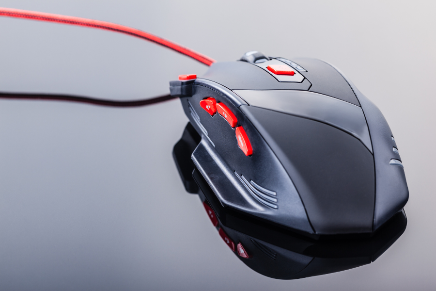 gaming mouse resting on reflective surface showcasing vibrant red buttons