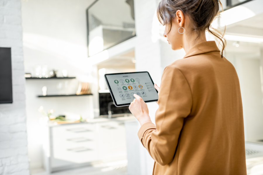 woman using tablet to control smart home system in kitchen