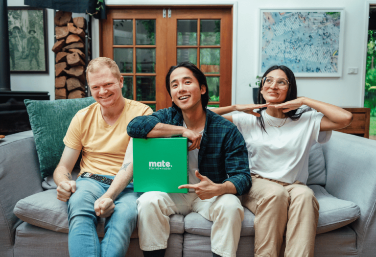 people sitting on couch holding mate rewards box in living room