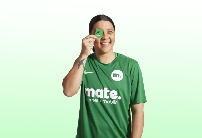 person holding chip, smiling, wearing green mate internet mobile shirt.